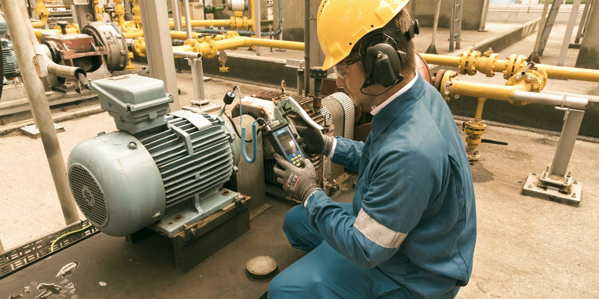Technician using a contact ultrasound probe to inspect a motor bearing